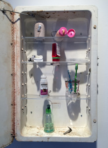 Tim Hawinson, World Clock, medicine cabinet, ace bandage, lotion bottle, prescription medicine bottle, dental floss, deodorant, toothbrushes, plastic cup, pump soap bottle, nail clipper and clock motors, 25 ½ x 16 x 21 inches, 2012.