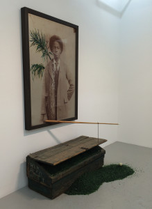 Radcliffe Bailey, Before Cisero, mixed media installation including a framed photograph printed on aluminum, a pool stick, a crate and crushed green glass, 91 ½ x 64 x 47 inches, 2016.